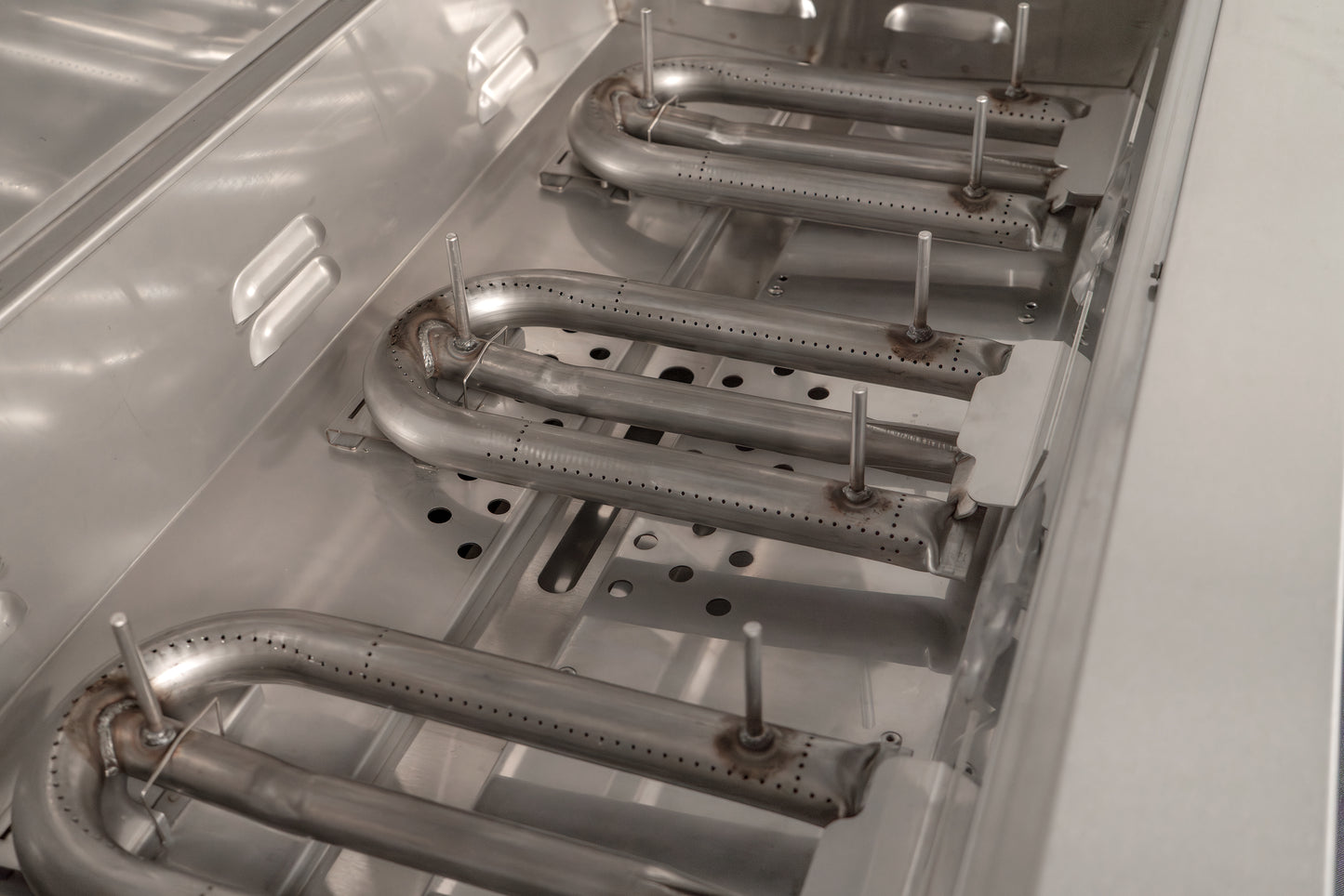 AOG Stainless Steel Burners installed in the lower housing of the grill body
